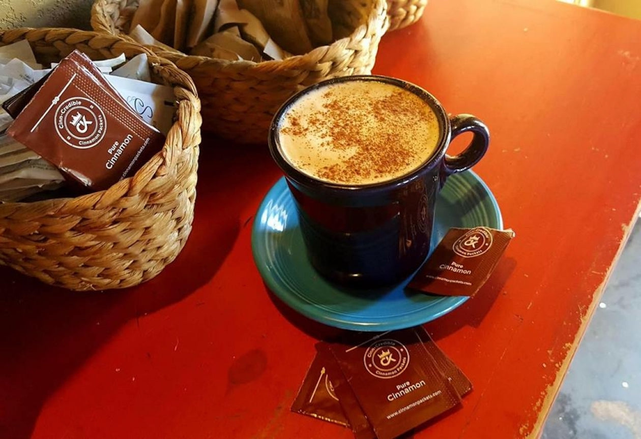 Cinnamon Packet being sprinkled into a cup of coffee