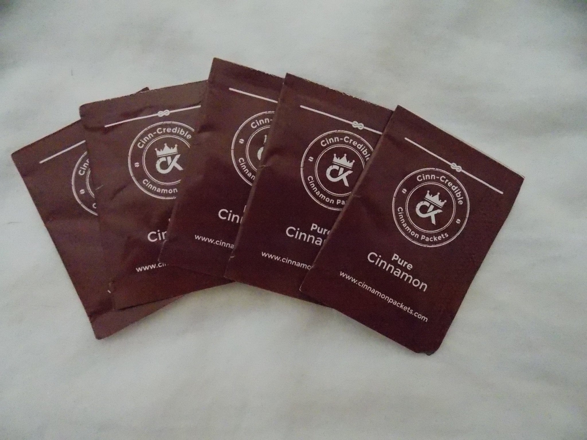 Five individual Cinnamon Packets fanned out on a table